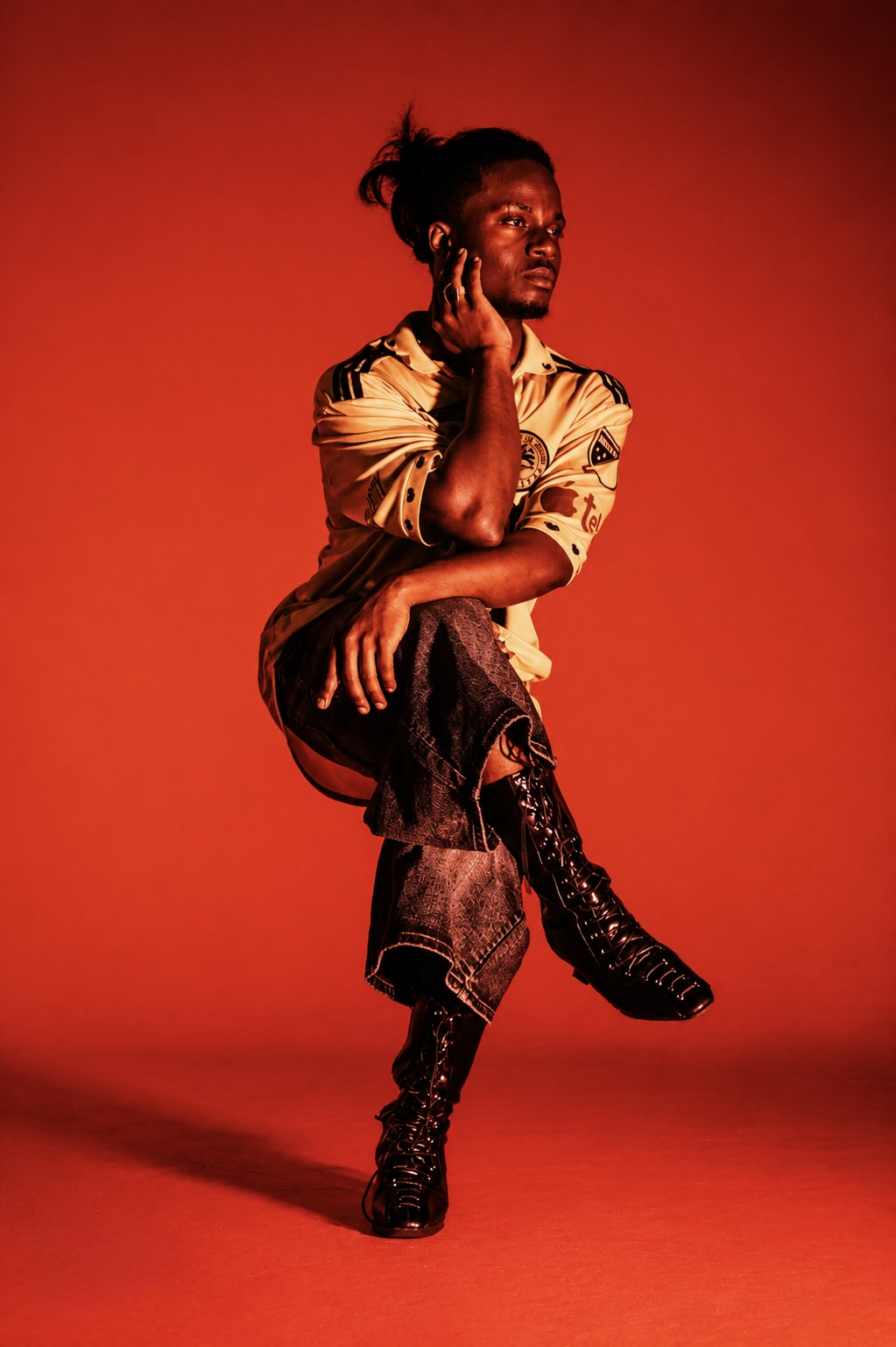 TERRANCE DEAN balancing on one leg in amber light