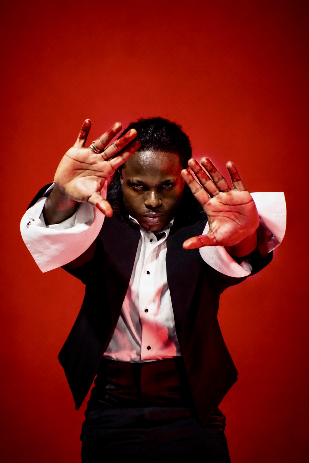 TERRANCE DEAN with hands raised against a red backdrop