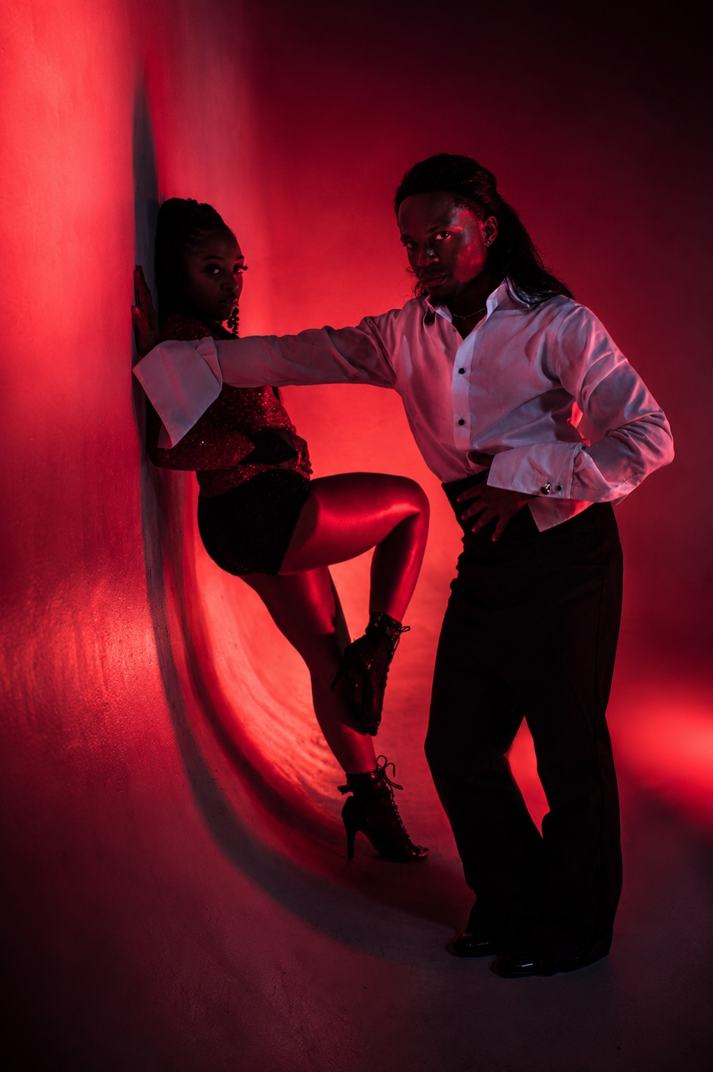TERRANCE DEAN and a dancer posing against a red-lit studio wall