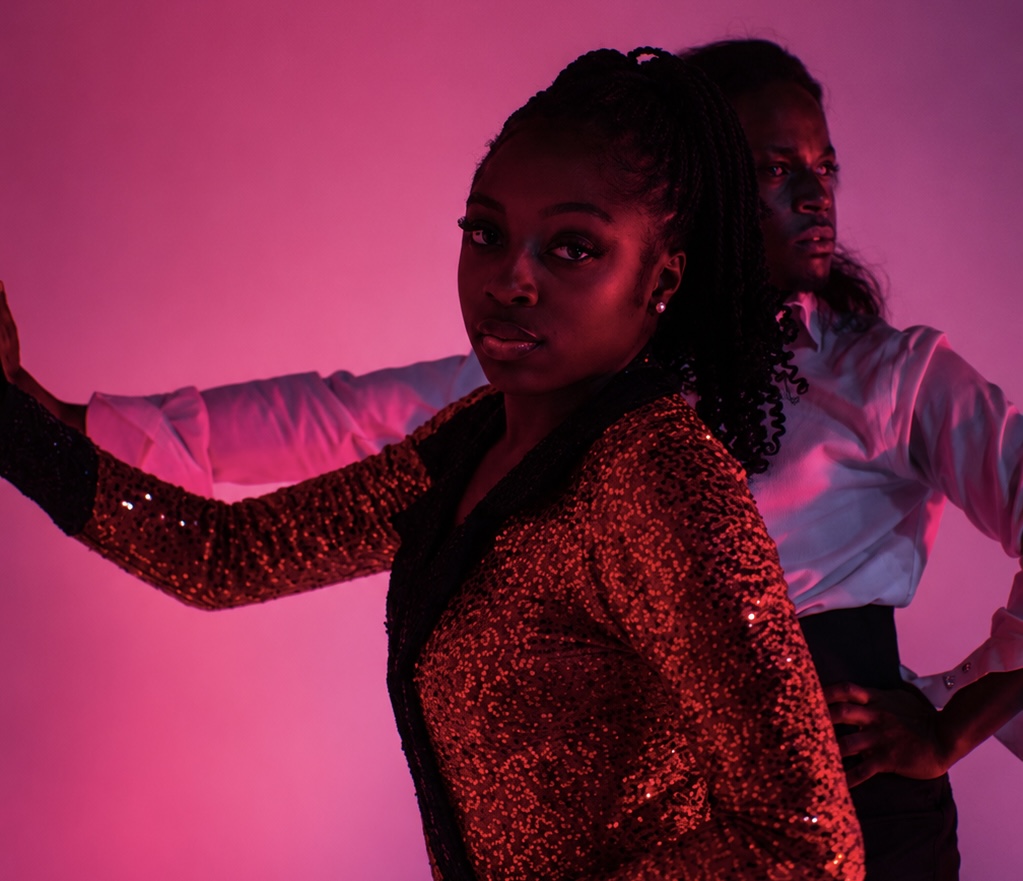TERRANCE DEAN and a dancer in a sequined red costume under pink light