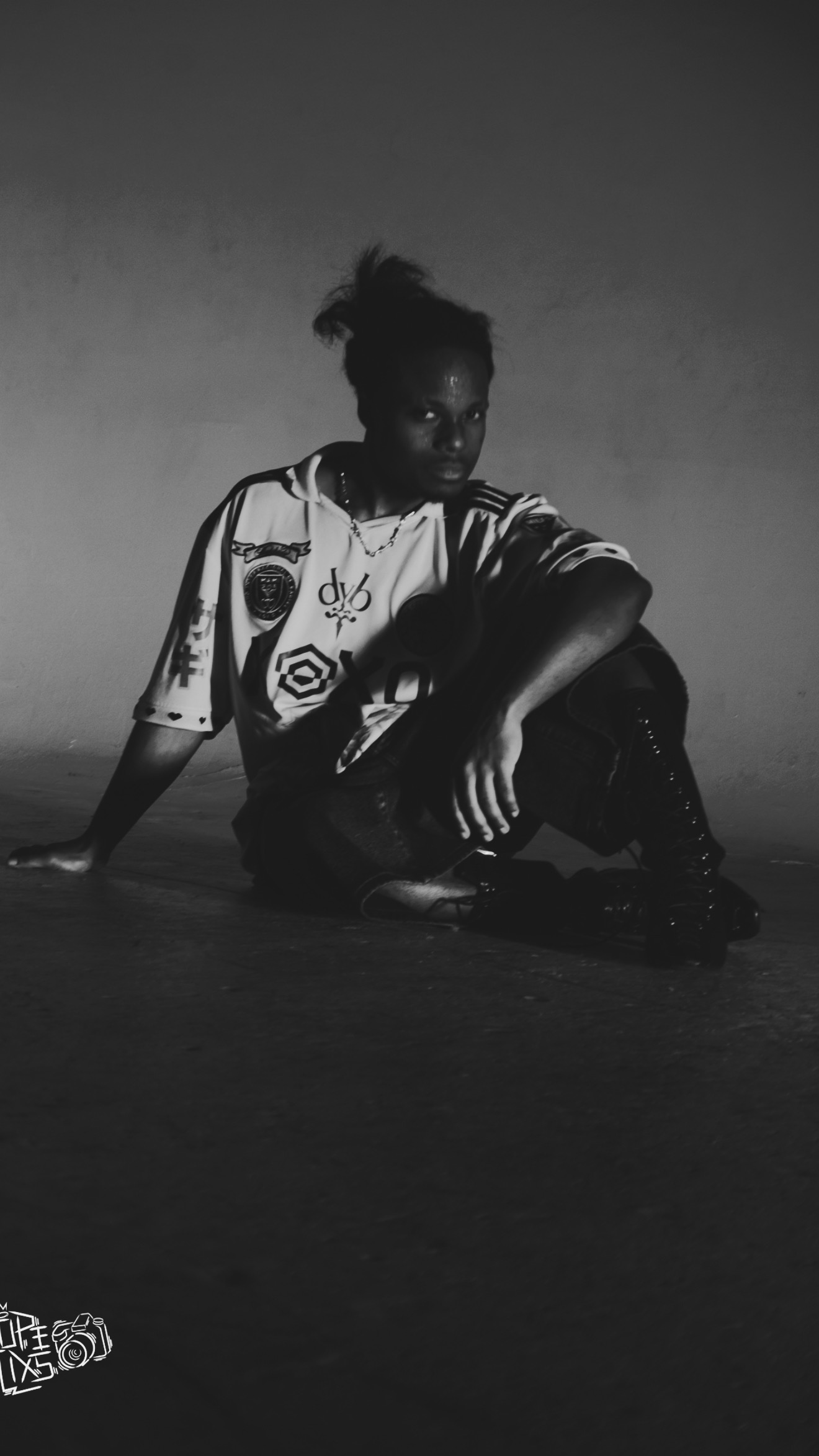 Black-and-white photograph of TERRANCE DEAN sitting on the studio floor