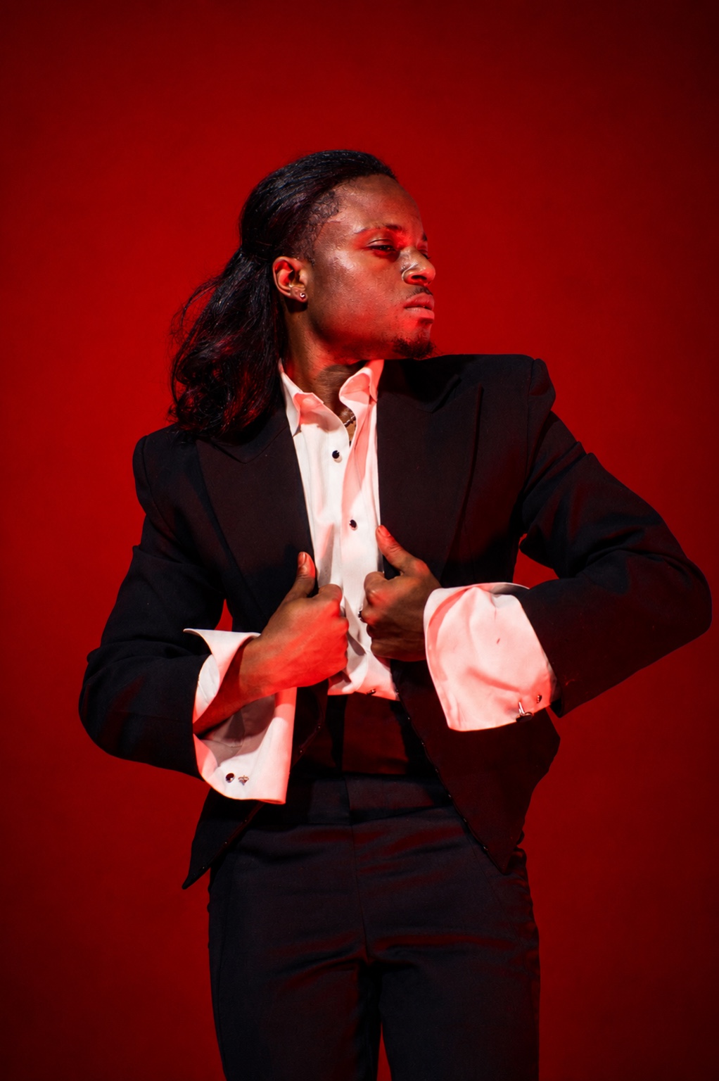 TERRANCE DEAN looking to the side with hands on a black suit jacket