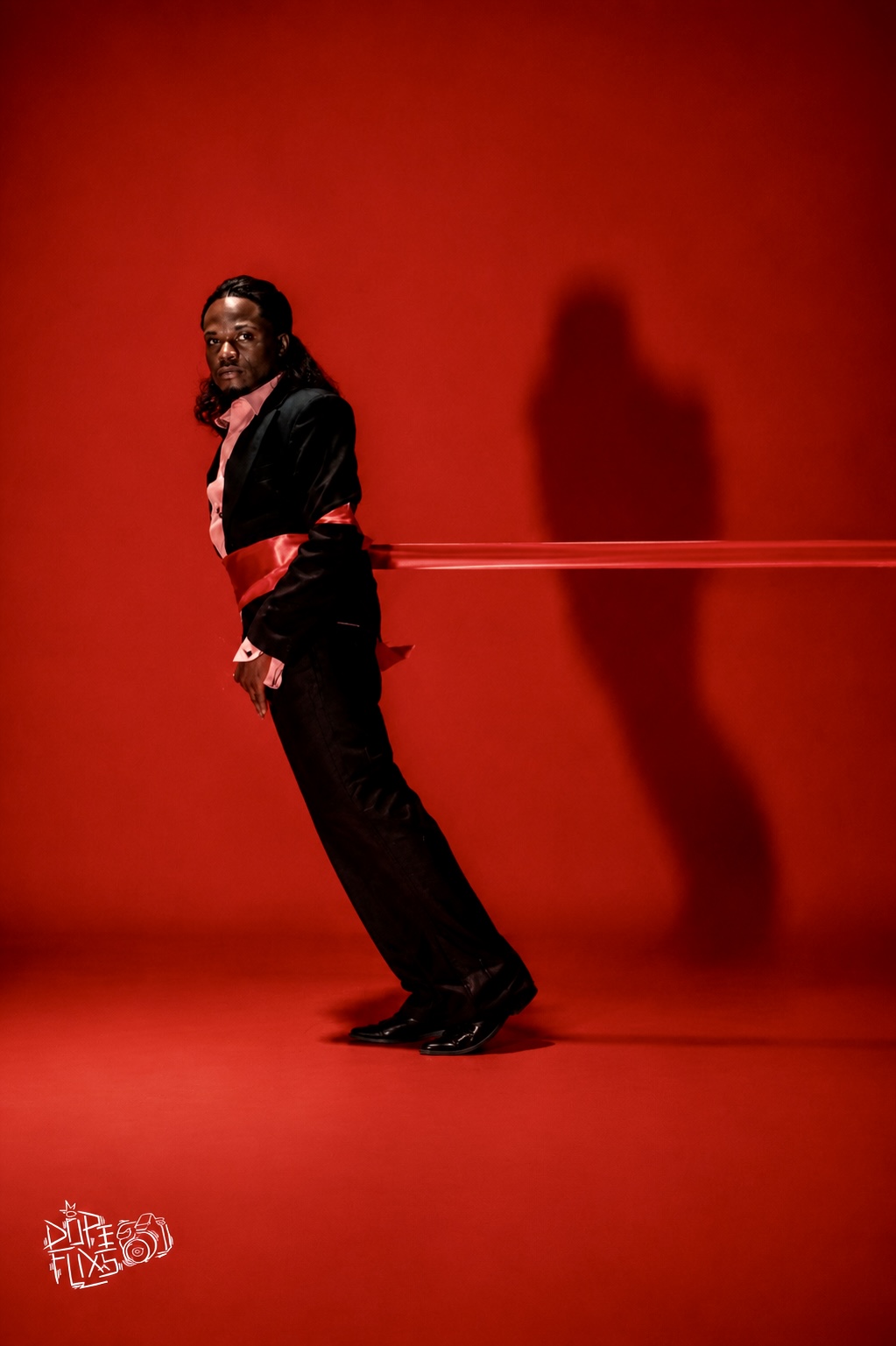 TERRANCE DEAN leaning forward against a ribbon and red background