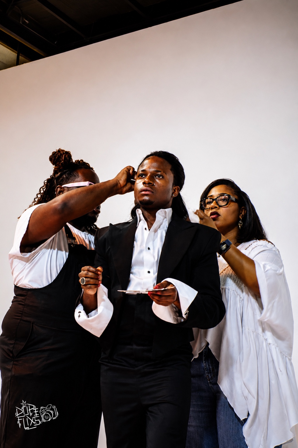 Collaborators adjusting TERRANCE DEAN’s look between photographs